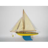 Star - A vintage Star of Birkenhead Pond Yacht in yellow with blue trim with its original sails.