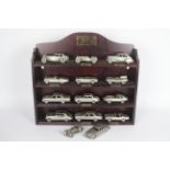 Danbury Mint - A boxed collection of 12 Danbury Mint Jaguar 1:43 scale pewter cars with wooden