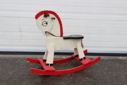 A red and white rocking horse. Appears to have some slight storage damage.