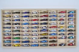 Hot Wheels - A wooden display cabinet containing 79 x loose Hot Wheels cars including Ford Escort