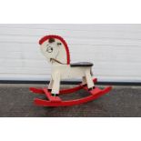 A red and white rocking horse. Appears to have some slight storage damage.