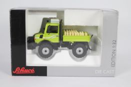 Schuco - A boxed 1:32 scale Mercedes Benz Unimog U1600 with front hydraulics and seed sack load.
