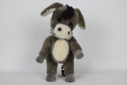 The Wild Things - A grey and black-coloured soft toy donkey. Donkey has glass eyes.