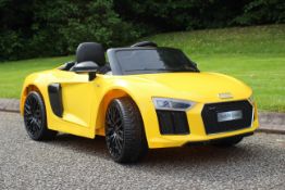 An Audi R8 Spyder Ride On Car - The rechargeable 12v car in yellow is licensed by Audi,