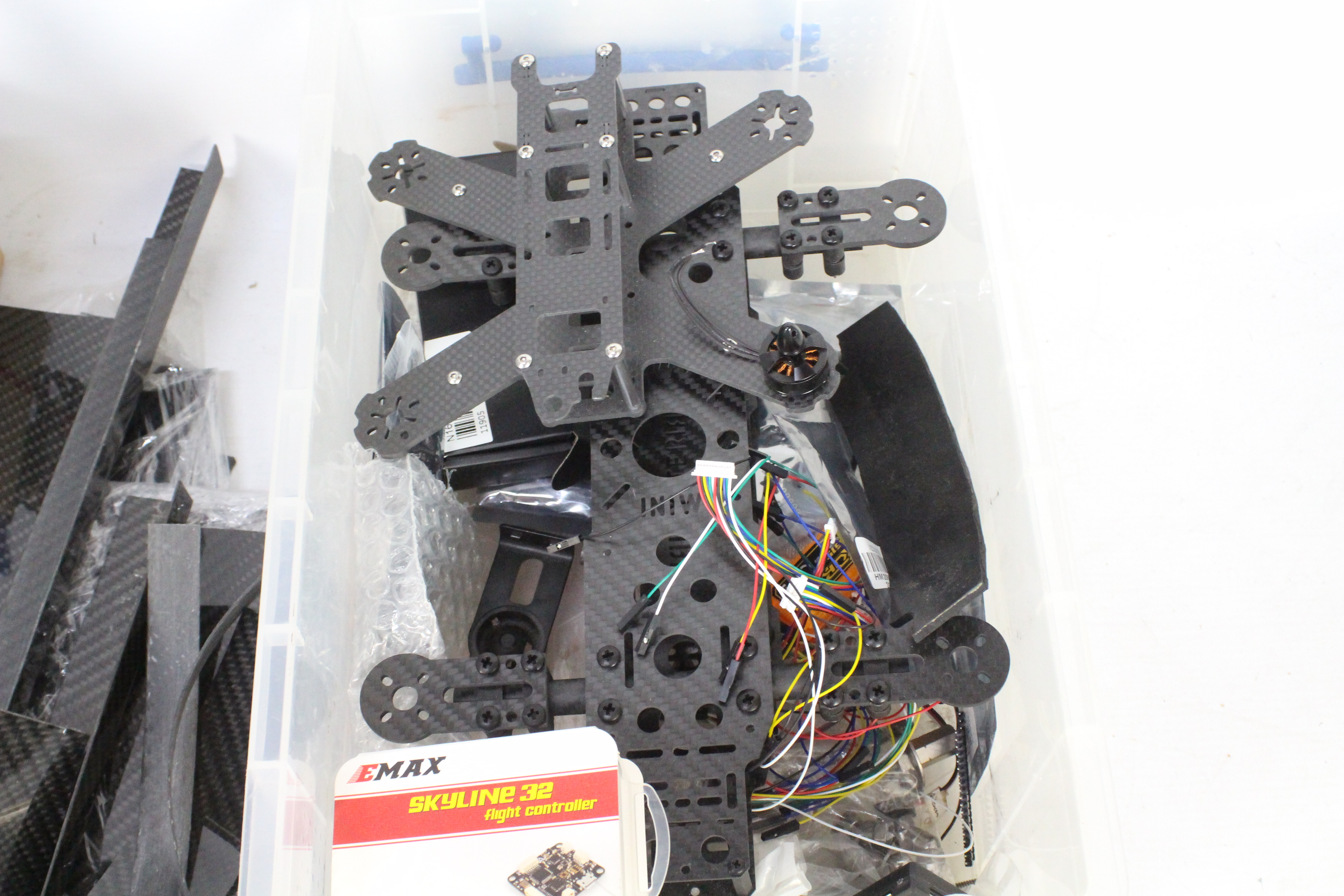 A collection of R/C spare parts and a carbon fibre quad copter frame with a box of brushless motors. - Image 4 of 5