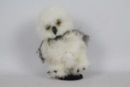 A soft toy snow owl. Owl has glass eyes, plastic beak and claws.