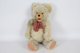 A white wool style plush jointed teddy bear with growler.