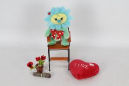A soft toy in the form of a flower, soft toy has a red bow and a plastic lady bird accessory.