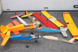 A mixed lot of scratch built remote control airplanes and parts and control surfaces with one