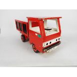 A vintage hand-made wooden tipper truck painted red with black panels and white driver's cab,