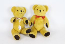 Two mohair teddy bears with glass eyes, suede paws, and stitched noses. Both bears have red bows.