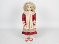 Bru Jne - A reproduction of a Bru Jne bisque head doll on stand.