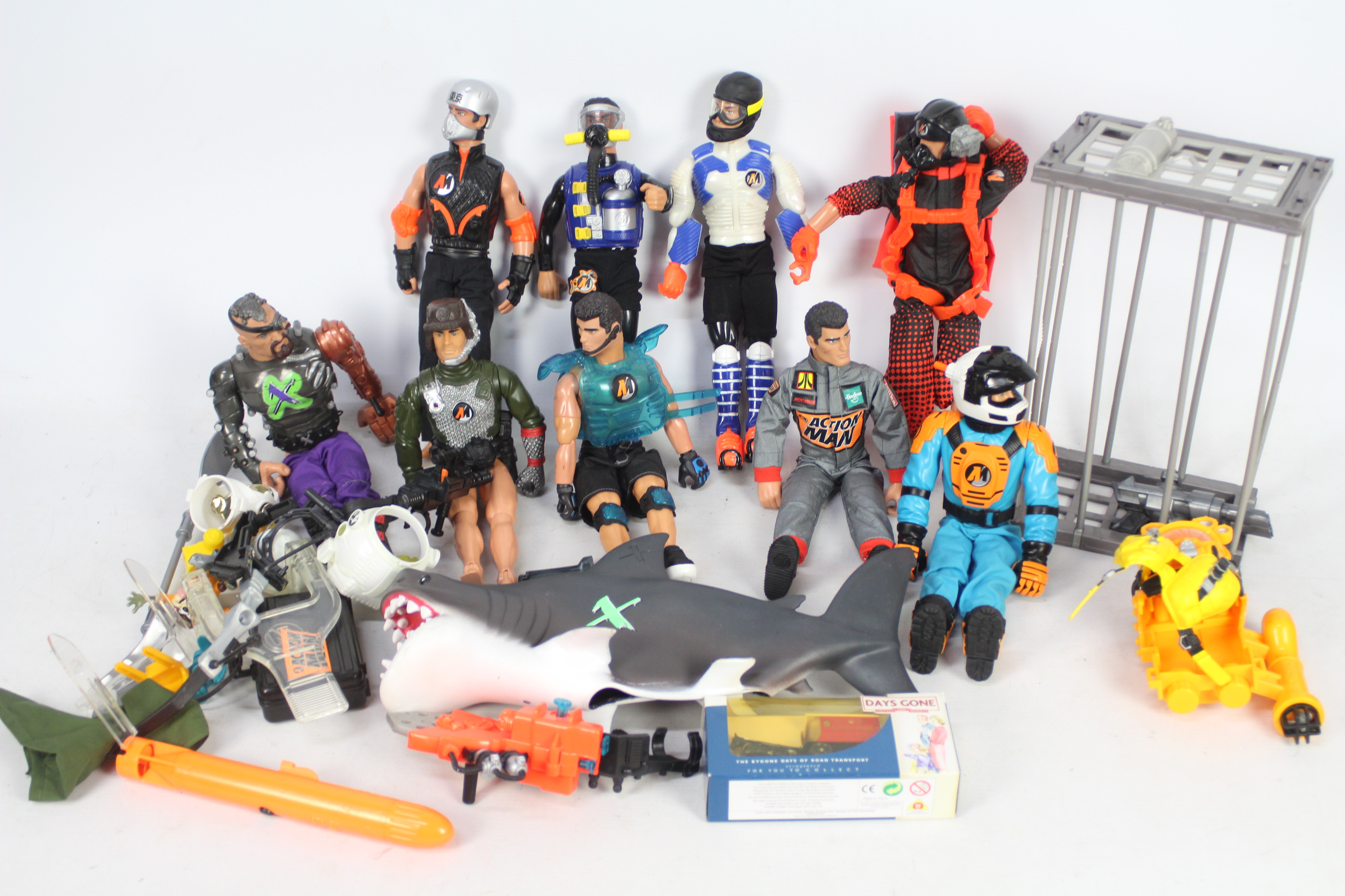A collection of nine loose Action Men with various accessories, cage and shark.