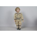 Kley & Hahn - A reproduction Kley & Hahn bisque head character doll of a boy on stand.