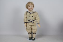 Kley & Hahn - A reproduction Kley & Hahn bisque head character doll of a boy on stand.