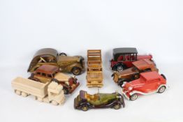 A collection of eight modern decorative wooden vehicles, one unpainted.