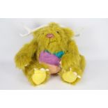 A yellow-coloured soft toy monster with white antlers and glass eyes.