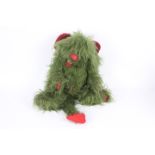 A dog and dragon hybrid soft toy. Appears in dark green colour with red wings.