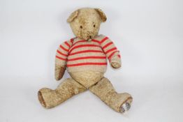 A large unmarked jointed vintage teddy bear. The golden wool type plush bear stands approx.