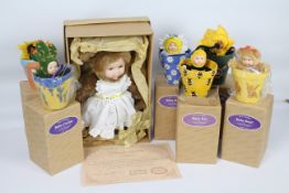 Anne Geddes Collector's dolls - A 38 cm doll in plush suit and cotton apron.