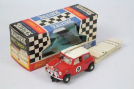 Scalextric - A boxed Scalextric #C7 'Race Tuned' Rally Mini Cooper slot car.