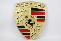 A large cast iron plaque advertising Porsche, approximate size 56.5 cm x 46.