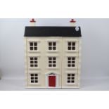 An unmarked opening front dolls house. The three storey unfurnished house measures approx.