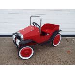 Vintage style pedal car in red.