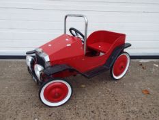 Vintage style pedal car in red.