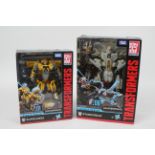 Takara, Tomy - Two boxed Transformers Studio Series series figures.