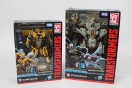 Takara, Tomy - Two boxed Transformers Studio Series series figures.