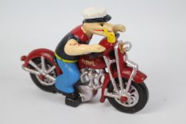 A cast iron model depicting Popeye riding a motorcycle, 16 cm (h).