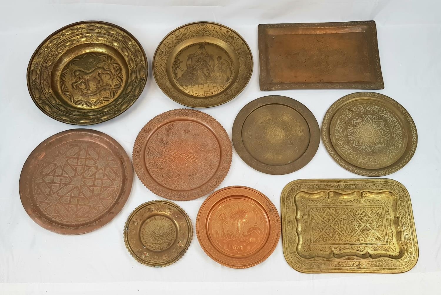 A SELECTION OF 10 INDIAN/PERSIAN VINTAGE BRASS AND COPPER SERVING TRAYS. ASSORTED SIZES.
