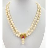 A TWIN STRING OF PEARLS SET IN 14CT GOLD DECORATED WITH PINK RUBIES AND A SMALL DIAMOND. WEIGHS 60.