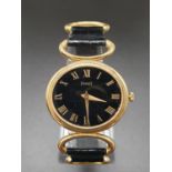 A Vintage Piaget Ladies Watch. 18k Gold case - 25mm. Black leather with gold links strap. Black