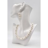 A sophisticated pearls and cubic zirconia necklace and earrings set with a very noticeable clasp