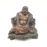 A late 19th Century, Chinese, hand carved, hard stone, smiling Buddha statue, on a wooden base, with