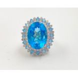 an 18ct white gold dress ring with a large topaz centre stone (4.5ct) surrounded by blue and white