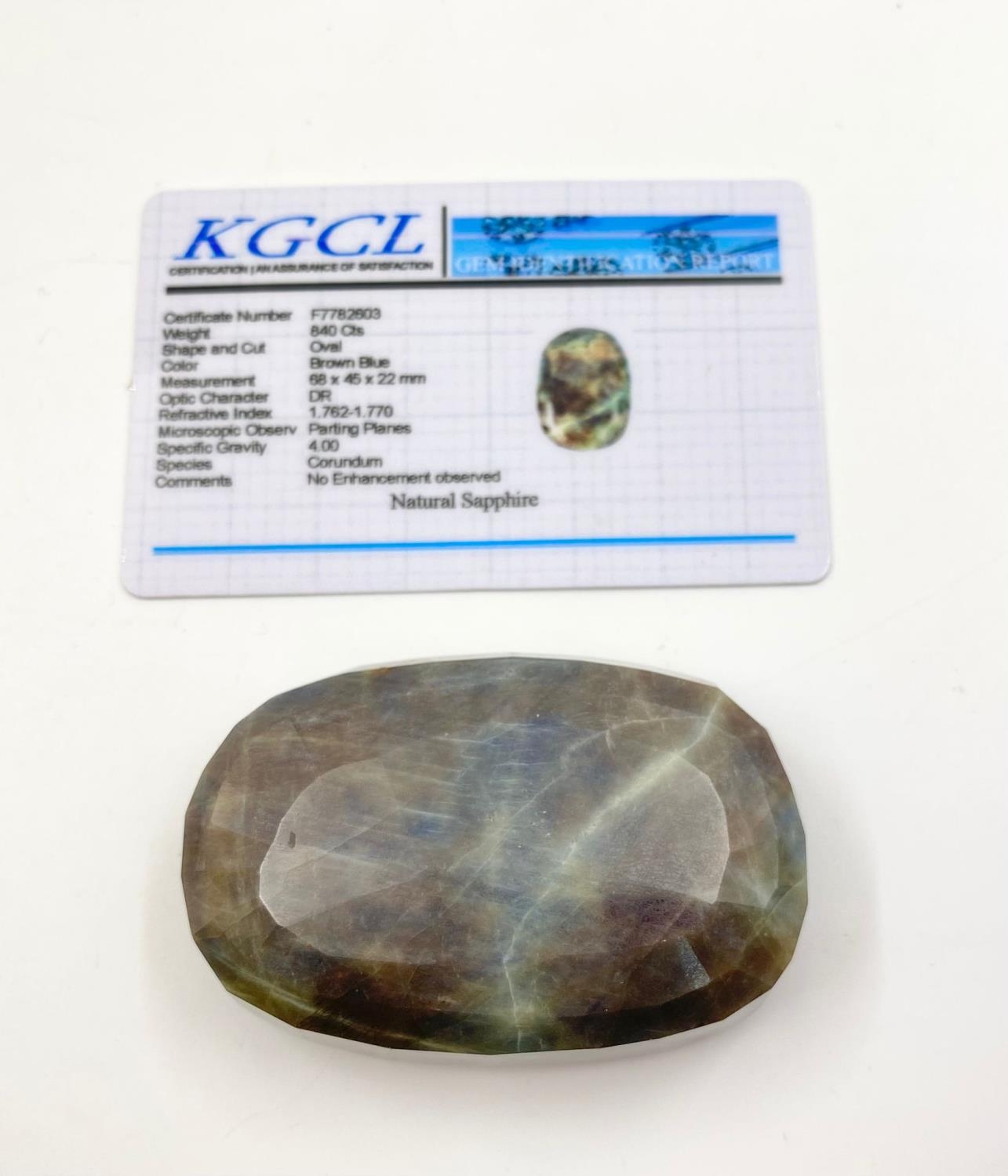 A natural 840ct brown/blue sapphire, oval cut, 68x45x22mm, KGCL certification.