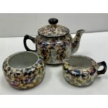 Classic style miniature teapot set including sugar bowl and milk pourer. Colourful spotted motif.