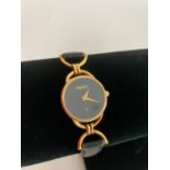 Ladies Quartz wristwatch having black face with marking showing Gucci. Watch case showing serial