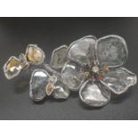 An impressive 18 K white gold brooch in the form of a flower with a butterfly. The petals are made