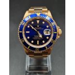 AN 18K GOLD ROLEX SUBMARINA WITH BLUE FACE AND MATCHING BLUE BEZEL . 40mm with service paper 23000