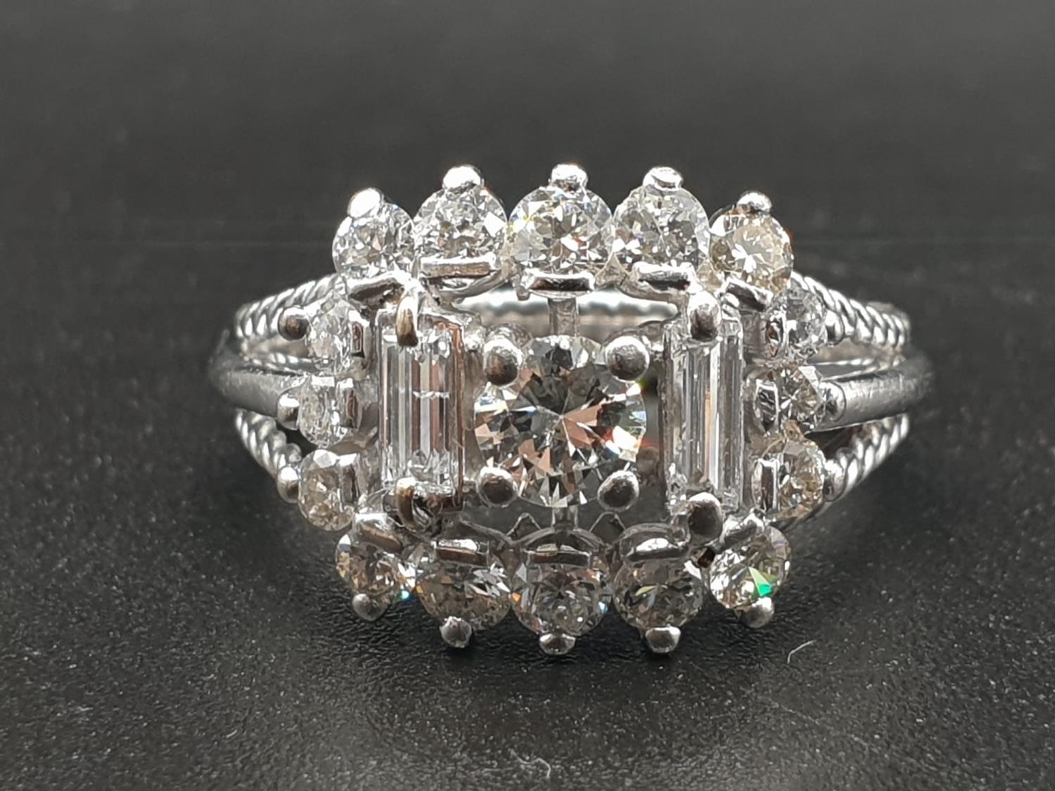 An 18 K (hallmarked) white gold ring with baguettes and brilliant cut diamonds. Ring size: O,