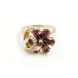 AN 18K WHITE GOLD DRESS RING WITH A ROTATING WHEEL OF AMETHYSTS AND DIAMOND DECORATION. 5.6gms