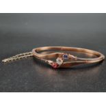 A rose gold bangle with a brilliant cut diamond, a Burmese Ruby and a Sri Lankan sapphire. With