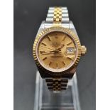 A LADIES ROLEX OYSTER PERPETUAL DATEJUST IN GOLD AND STEEL WITH GOLDTONE FACE . 26mm WITH ORIGINAL