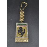 A FERRARI 18K GOLD KEY RING WITH DIAMONDS , EMERALD , RUBY AND A BLACK ONYX BACK. 89.8gms