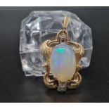 14k yellow gold pendant featuring a large 21mm opal with accompanying diamond and ruby stones in a
