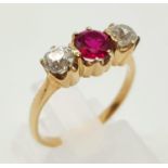 A Yellow Gold Diamond and Ruby Ring. A centre stone ruby with a bright diamond either side. Size